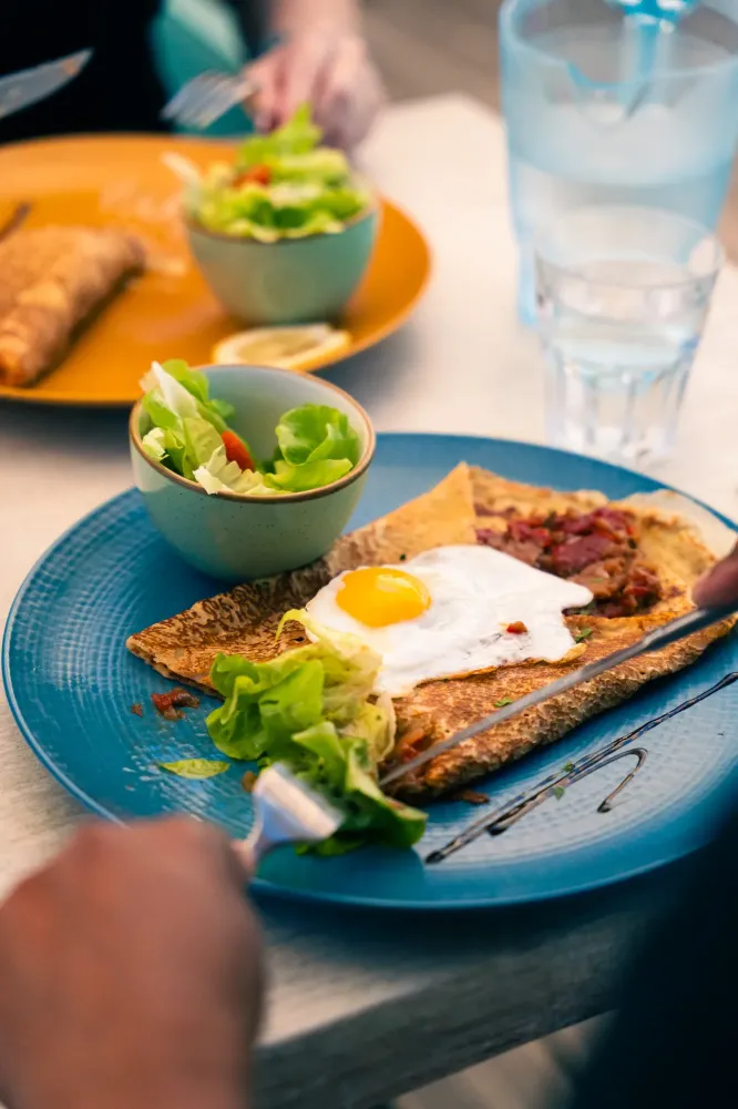 Crêpe avec un oeuf dans une assiette turquoise