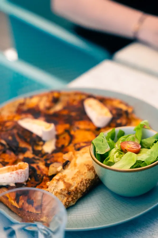 Assiette avec une crêpe salée et un bol de salade
